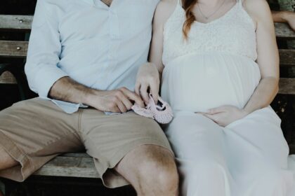 close-up photo of man and woman sitting on bench