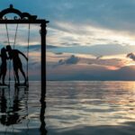 a couple standing in the sea while kissing