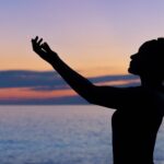 silhouette of woman raising her right hand