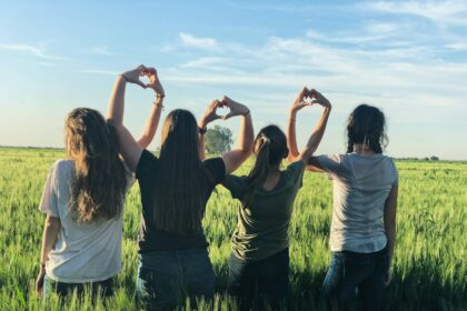 women forming heart gestures during daytime